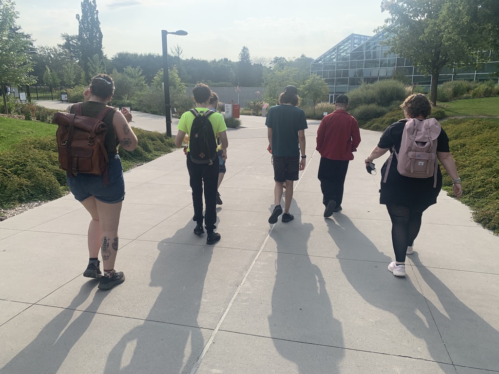 Several people walking away from the camera, towards the Insectarium and its many Bugs