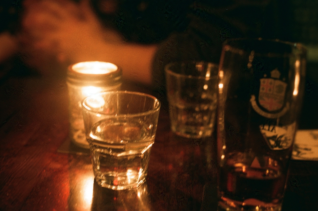 drinks, candles, and glasses on a bar table