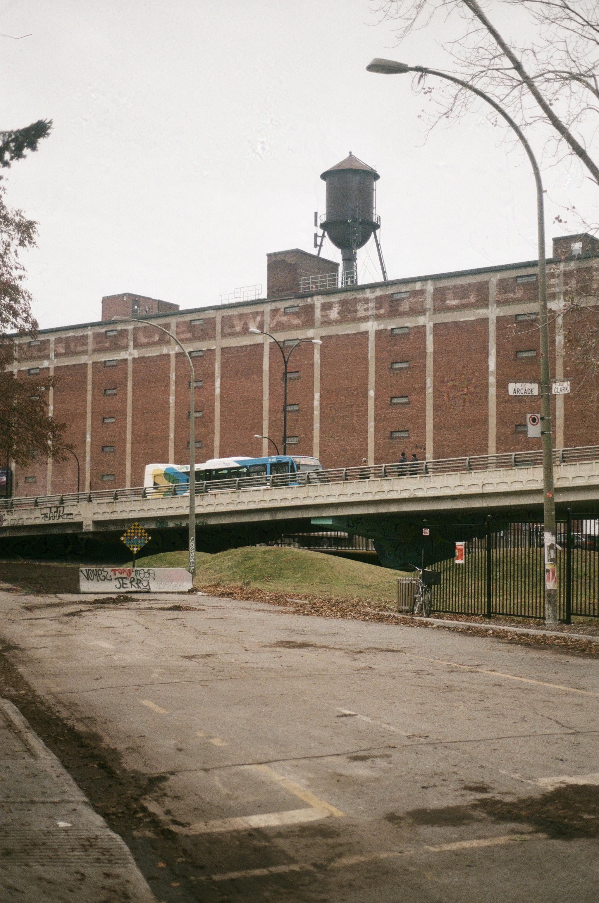 a city bus climbs the overpass in front of the Van Horne Warehouse & water tower