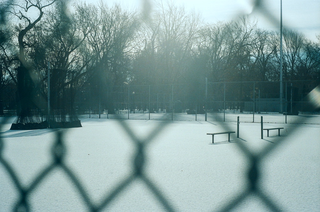 Snowed-over tennis courts, with nets put away for the season