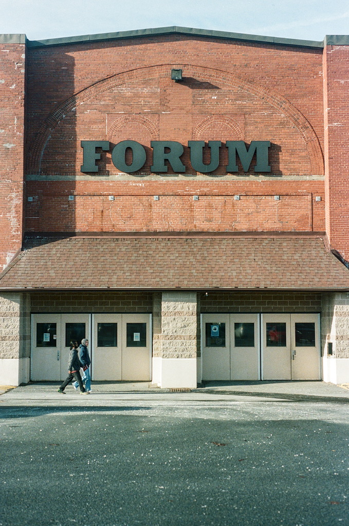 Two people walk in front of the doors of the Halifax Forum