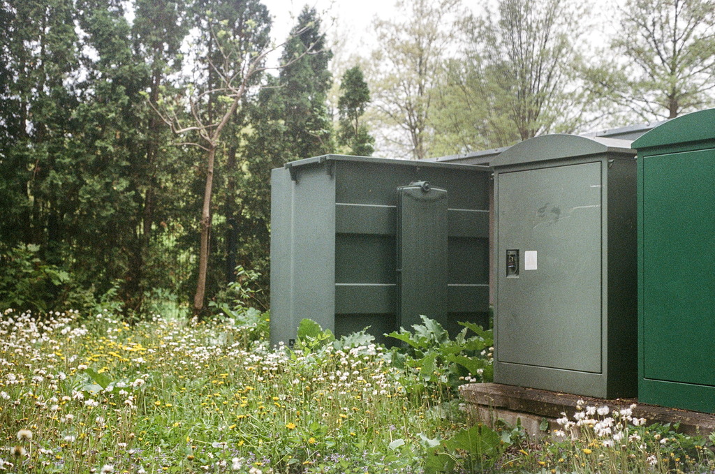 Transformers and other infrastructure sheds among weeds in the park