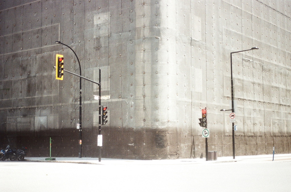A building covered by protective meshing, at the corner of Notre-Dame and Peel