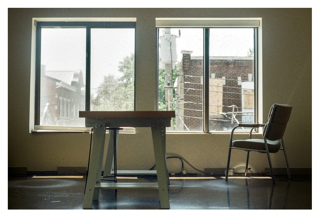 A drafting desk and chair by a sunny window