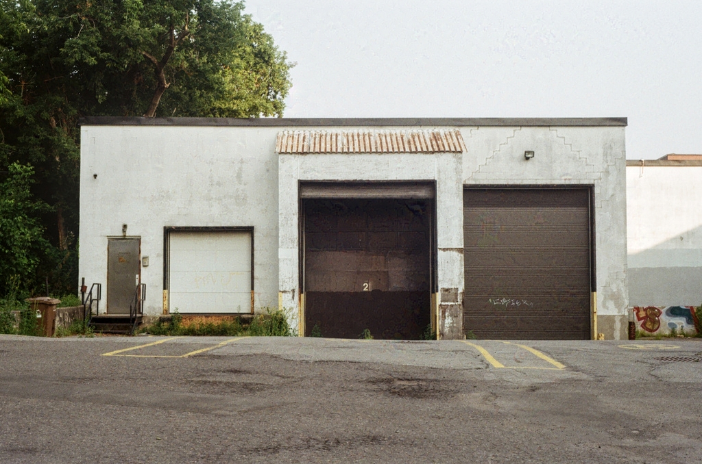 A sun-worn auto garage, with one bay slightly open
