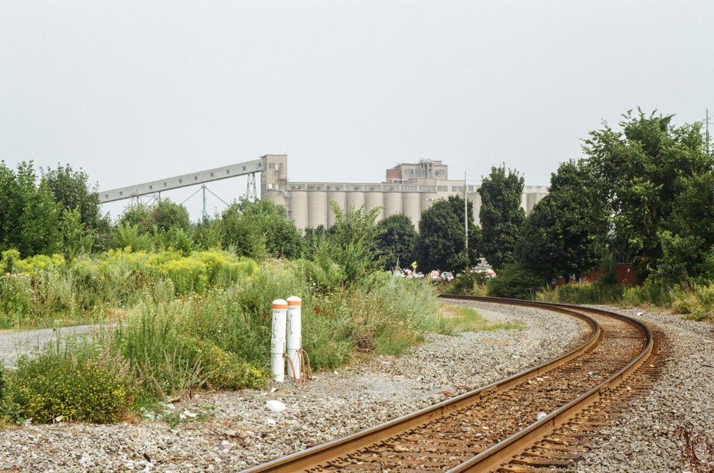 Railway tracks leading to grain silos, in the distance