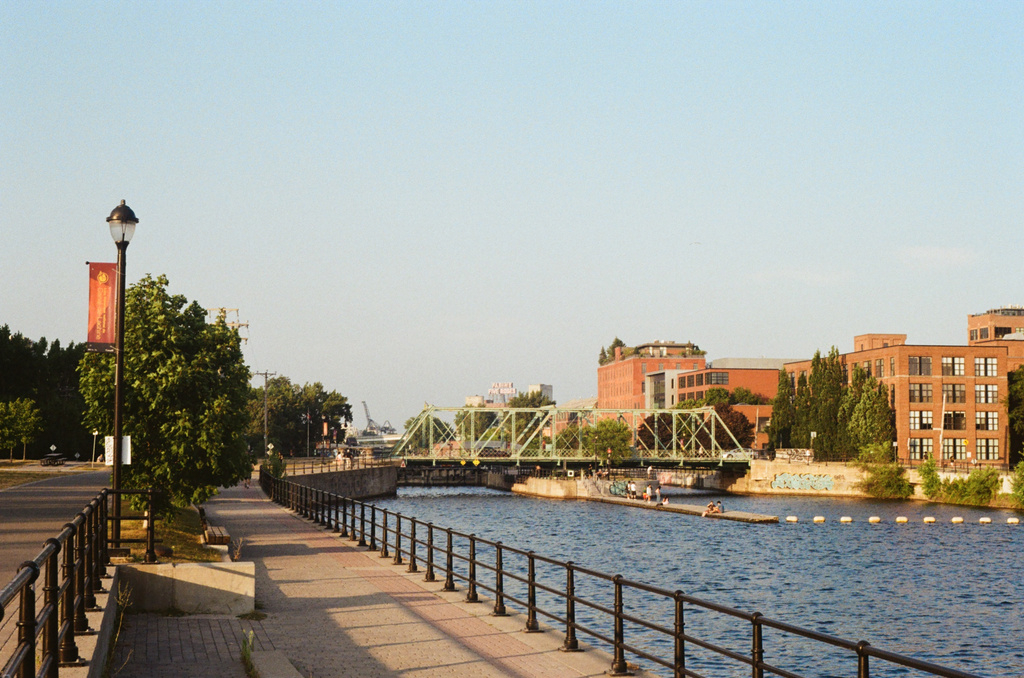 A view down the Lachine Canal at sunset, past les écluses Saint-Gabriel, with the Five Roses sign in the distance