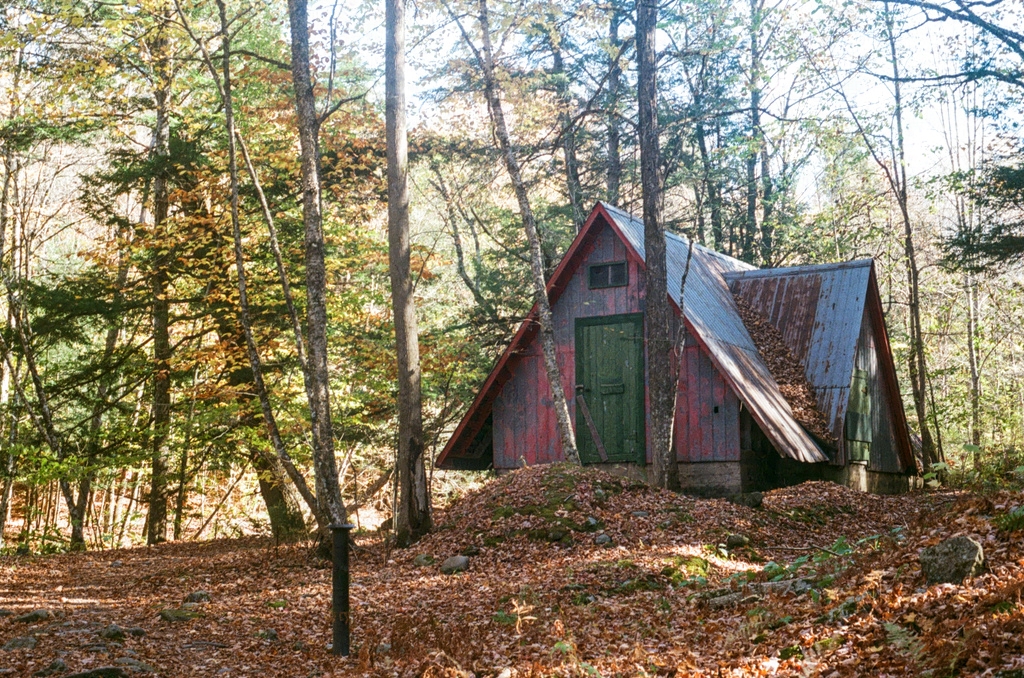 A red, A-frame cabin in the woods
