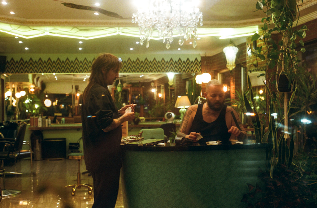 Two people in a salon window, closing for the night