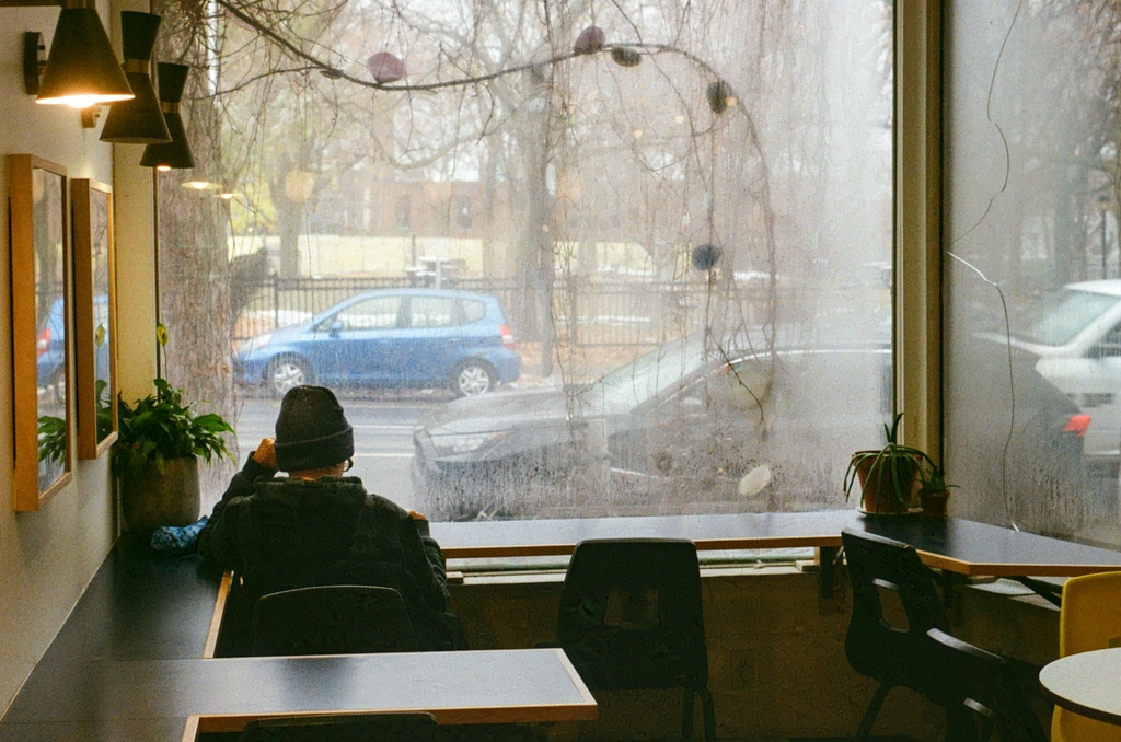 A person sitting at a counter table in a steamy coffee shop