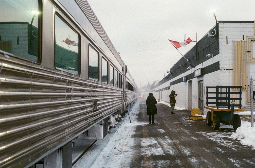 The train platform in Campbellton, under a dusting of snow, with a Via worker in silhouette