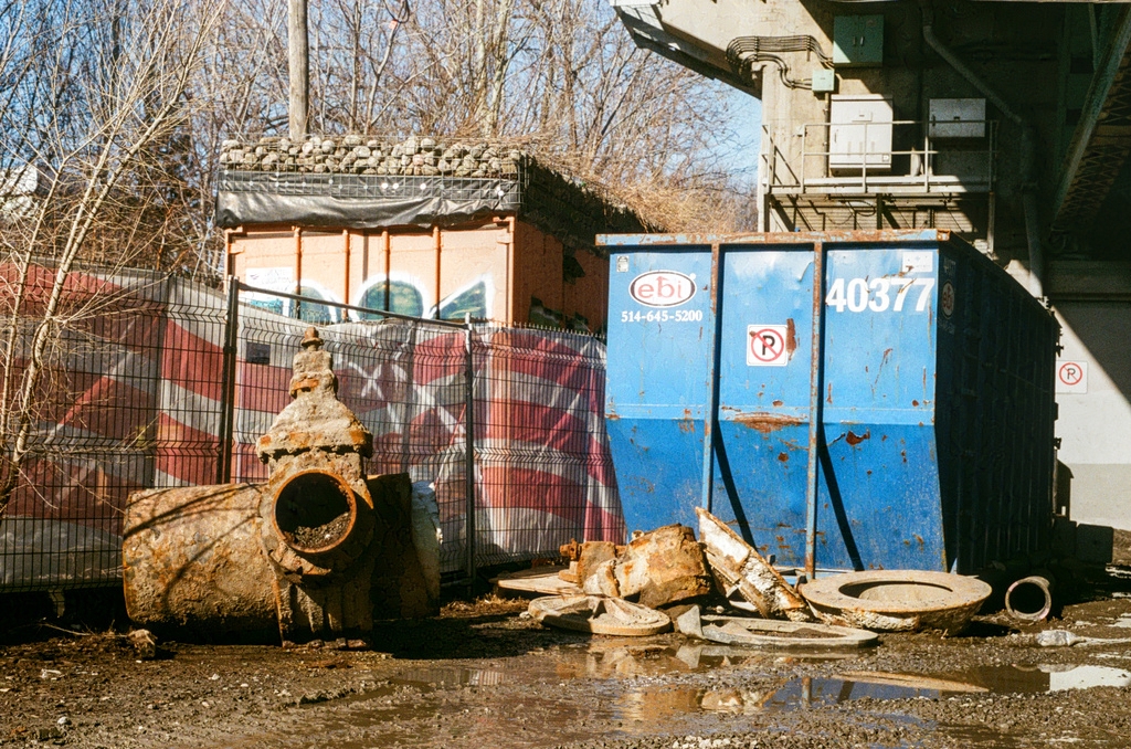 A blue cargo container and a rusty piece of municipal plumbing