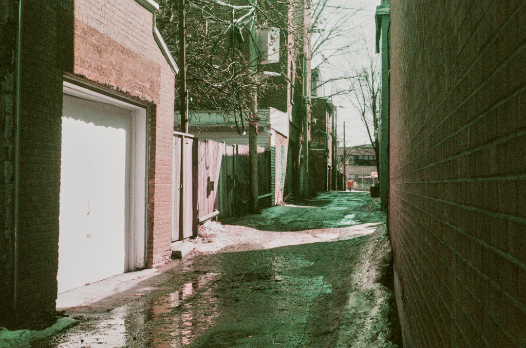 An empty alleyway, with some dregs of snow and melt