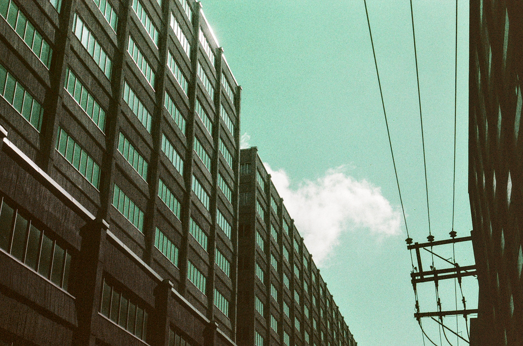 Tall, regular warehouse buildings in front of a blue sky