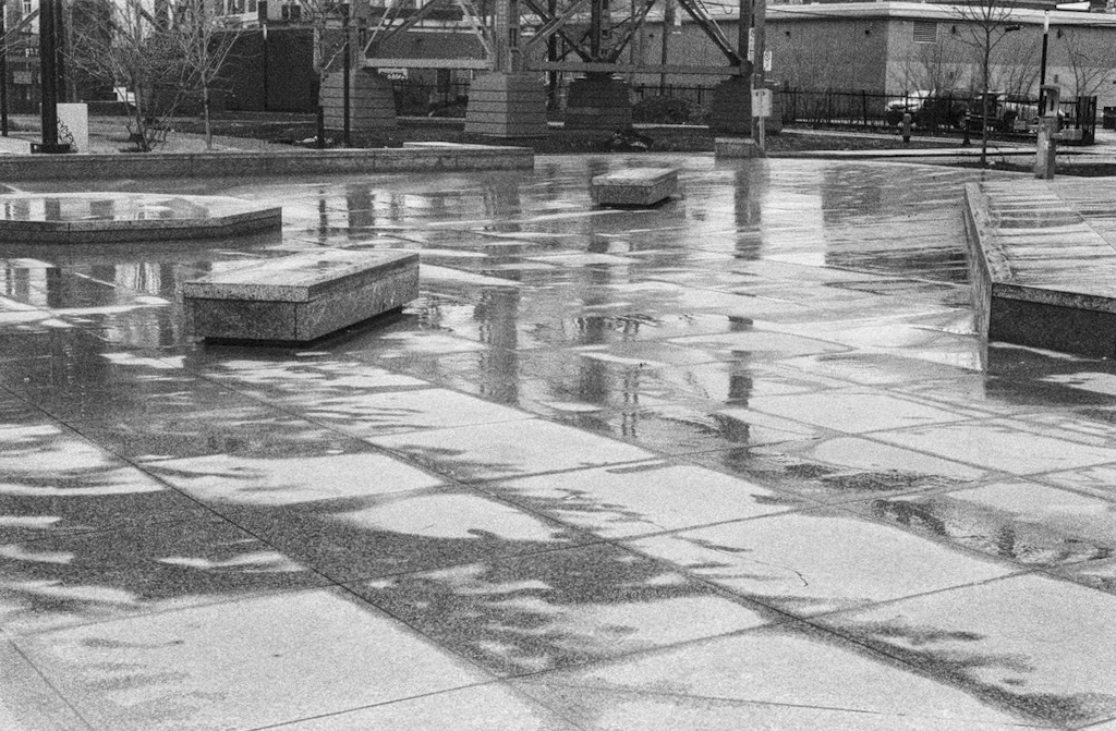 Rain-slicked concrete tiles in an empty plaza