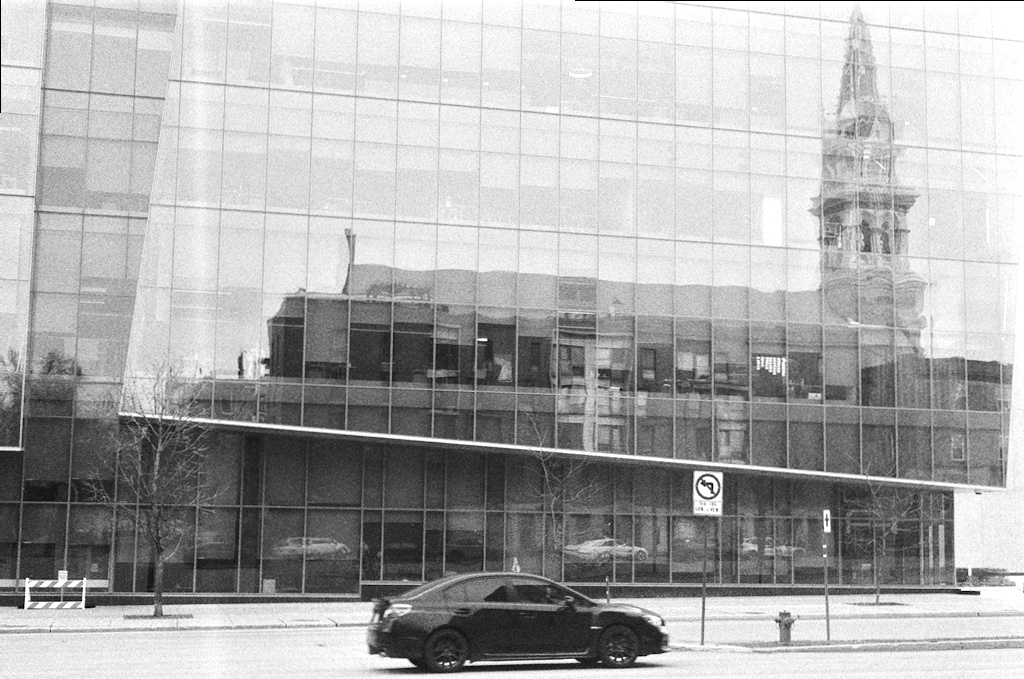 Distorted reflection of a church in a glass office façade