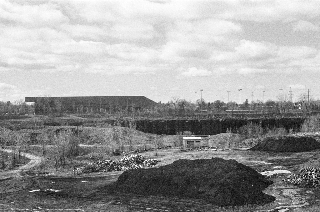 Mounds of dirt and an illuminated cabin in an abandoned quarry