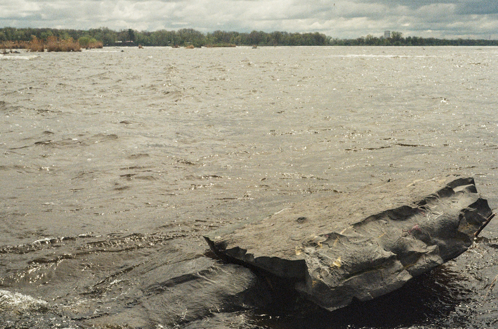 A large, wide rock sitting just above the water line
