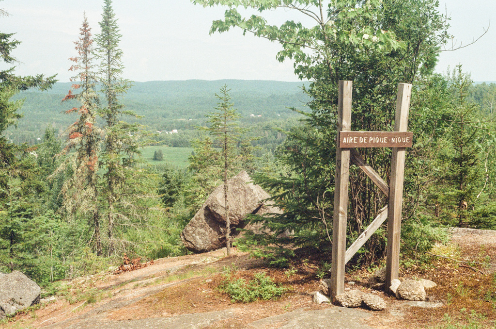 A wooden sign and a boulder on a lookout over Saint-Alexis-Des-Monts