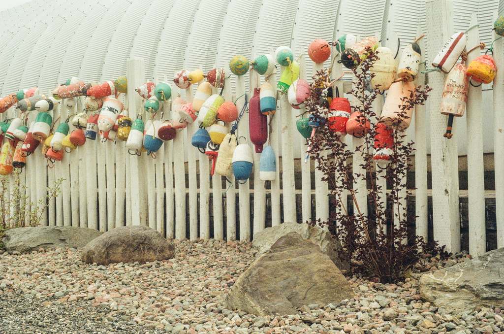 A long string of varied lobster floats decorating the side of a quonset hut