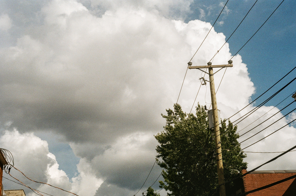 A large, fluffy cloud, with power lines in the foreground