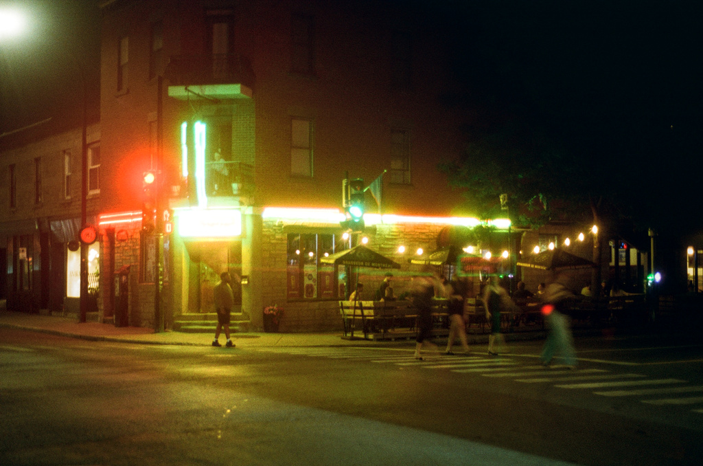 The same bar at night, more pedestrians visible
