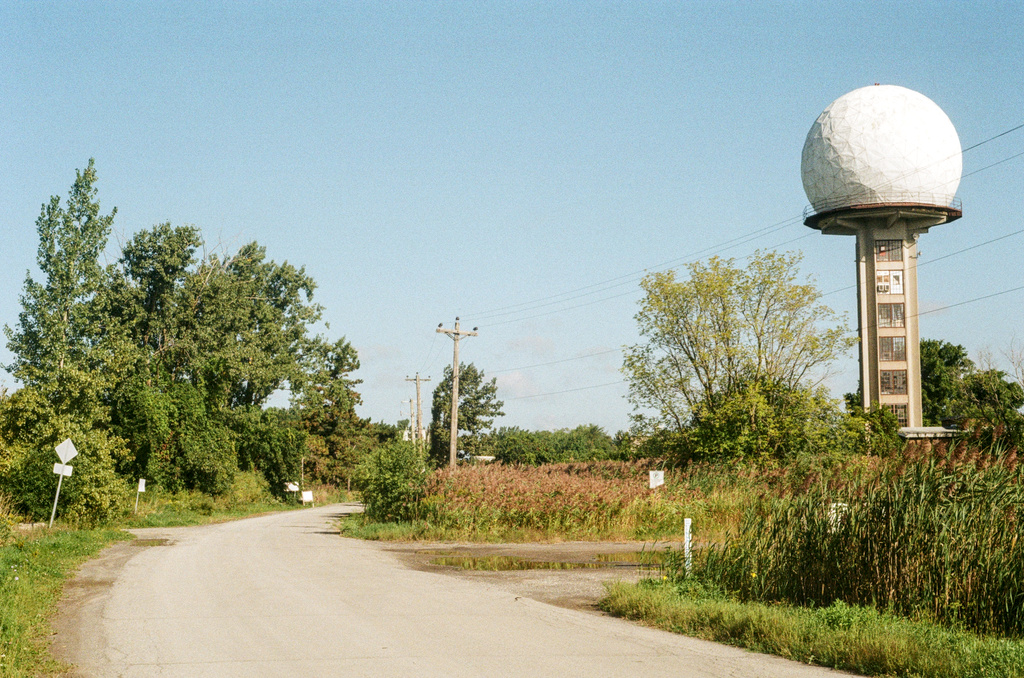 A golf ball-like radar dome by a rural road