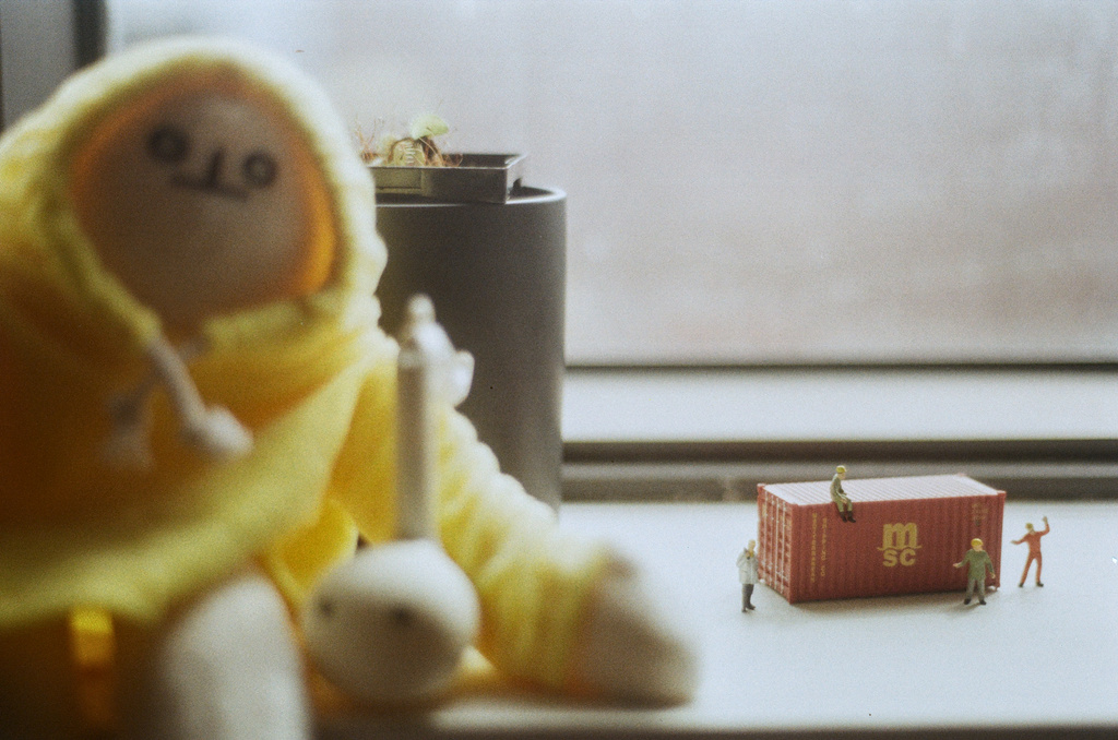 Miniature dock workers by a miniature cargo container on a windowsill