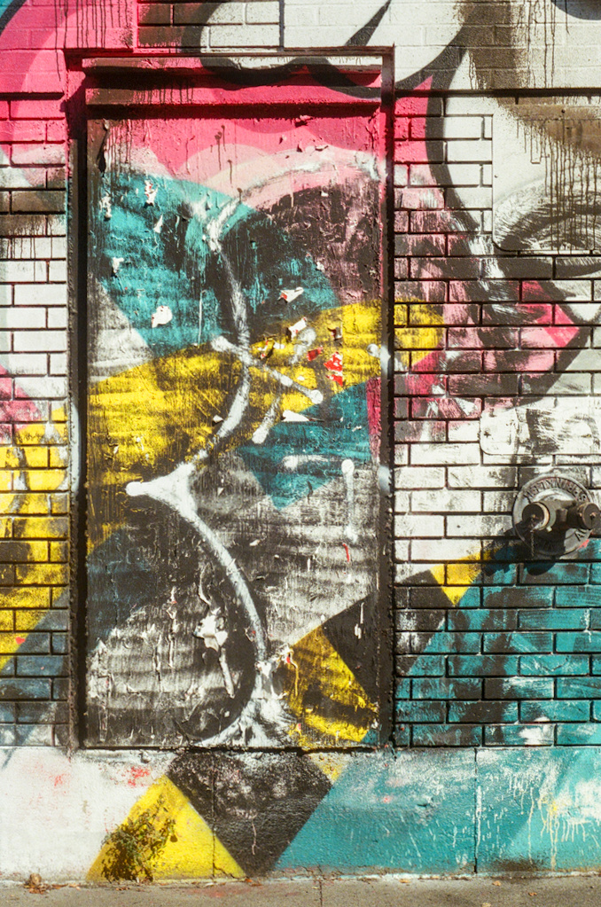 Colourful graffiti covers a brick wall and an inset surface