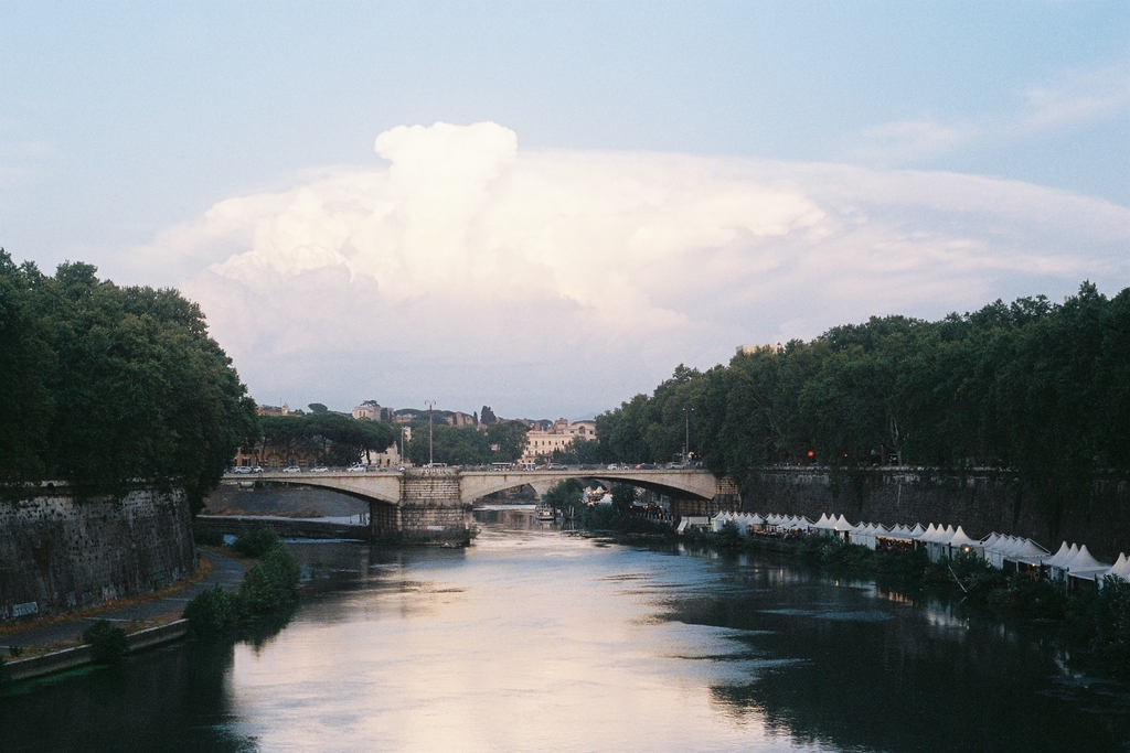 Another bridge, more clouds, and kiosks set up at the river's edge