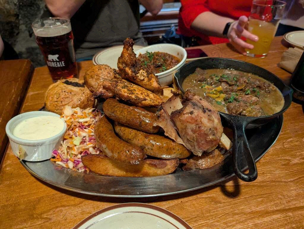 A plate stacked high with meats in various formats