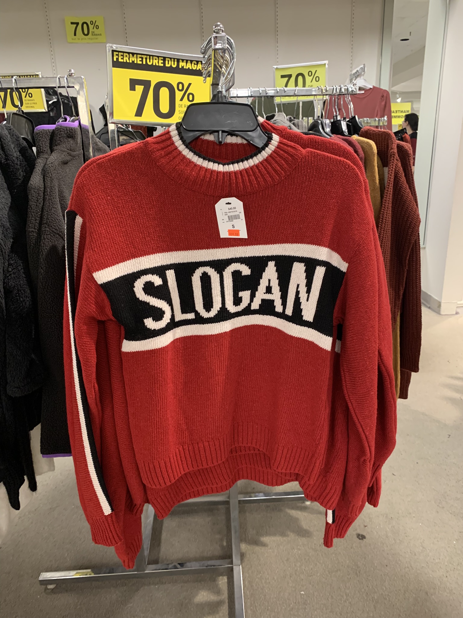 Store-closure sale, various clothes are 70% off, including a sweater reading 'SLOGAN' across the chest