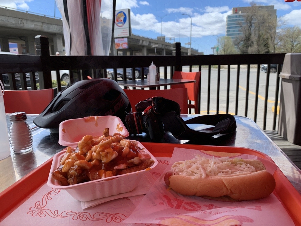 A table setting with a poutine and a hot dog